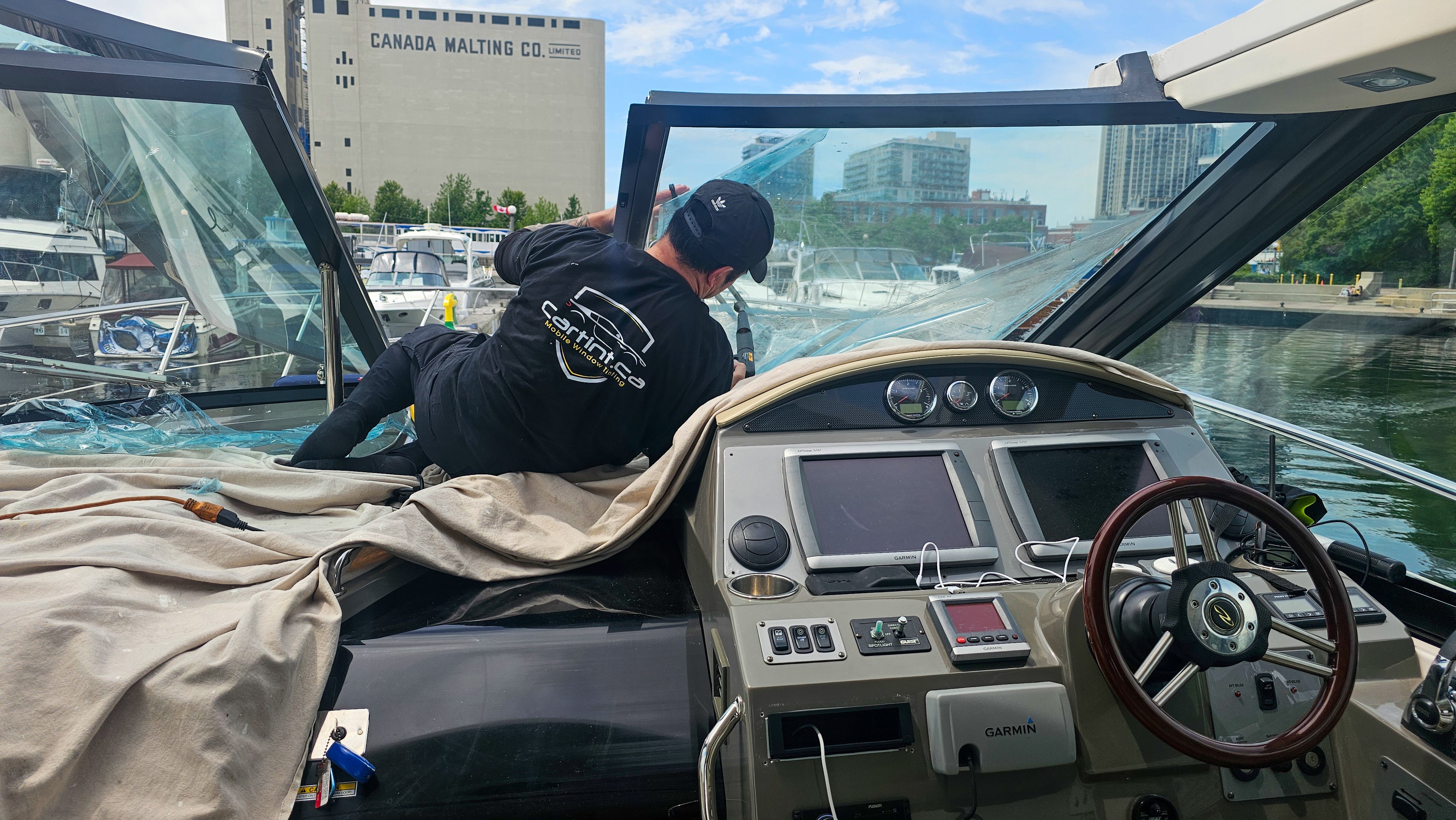 Window tinting installer from Car Tint, installing ceramic window tinting to a boat. The wimdow tinting  is for heat and uv protection, with a clear view visivility. Car Tint, window tinting near me