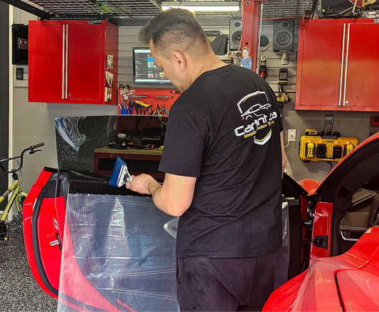 Professional mobile window tinting technician applying high-performance Nano-Ceramic film to a sports car in a luxury residential garage. Premium heat rejection window tinting price in Toronto starting at $350. Window tinting tint with top.of the line nano.ceramic indow film