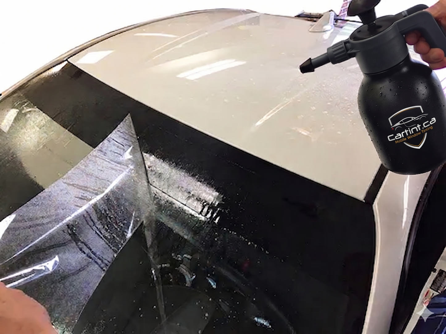Close-up of our expert car window tinting process, showing a windshield sun strip being carefully installed to block blinding sun glare and harmful UV rays.